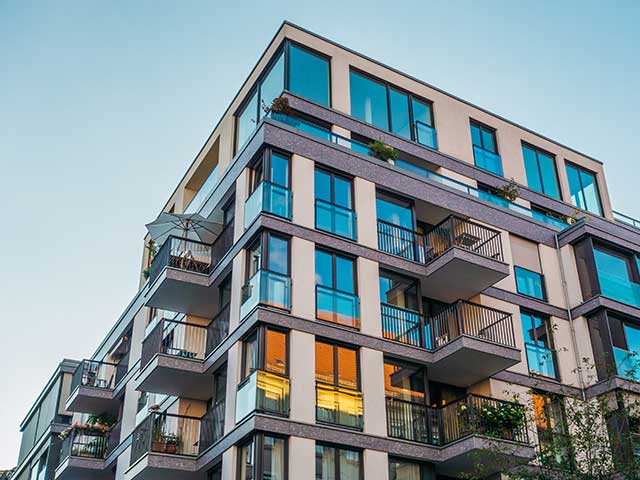 modern-corner-apartment-complex-with-blue-colored-windows-and-light-leaks